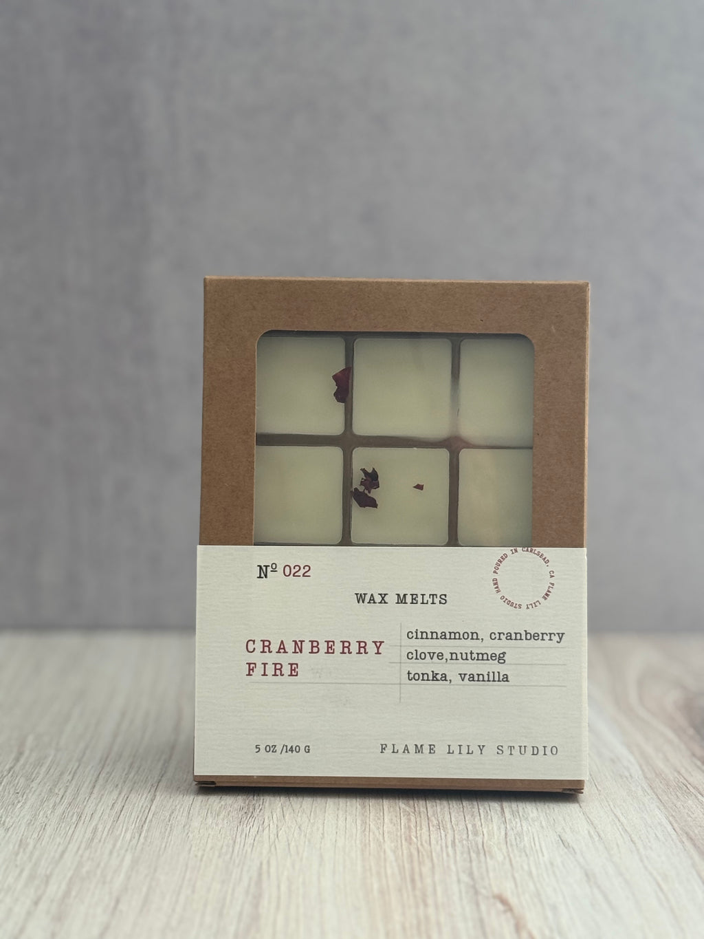 Wax melts packaging with 'Cranberry Fire' scent on a wooden surface.