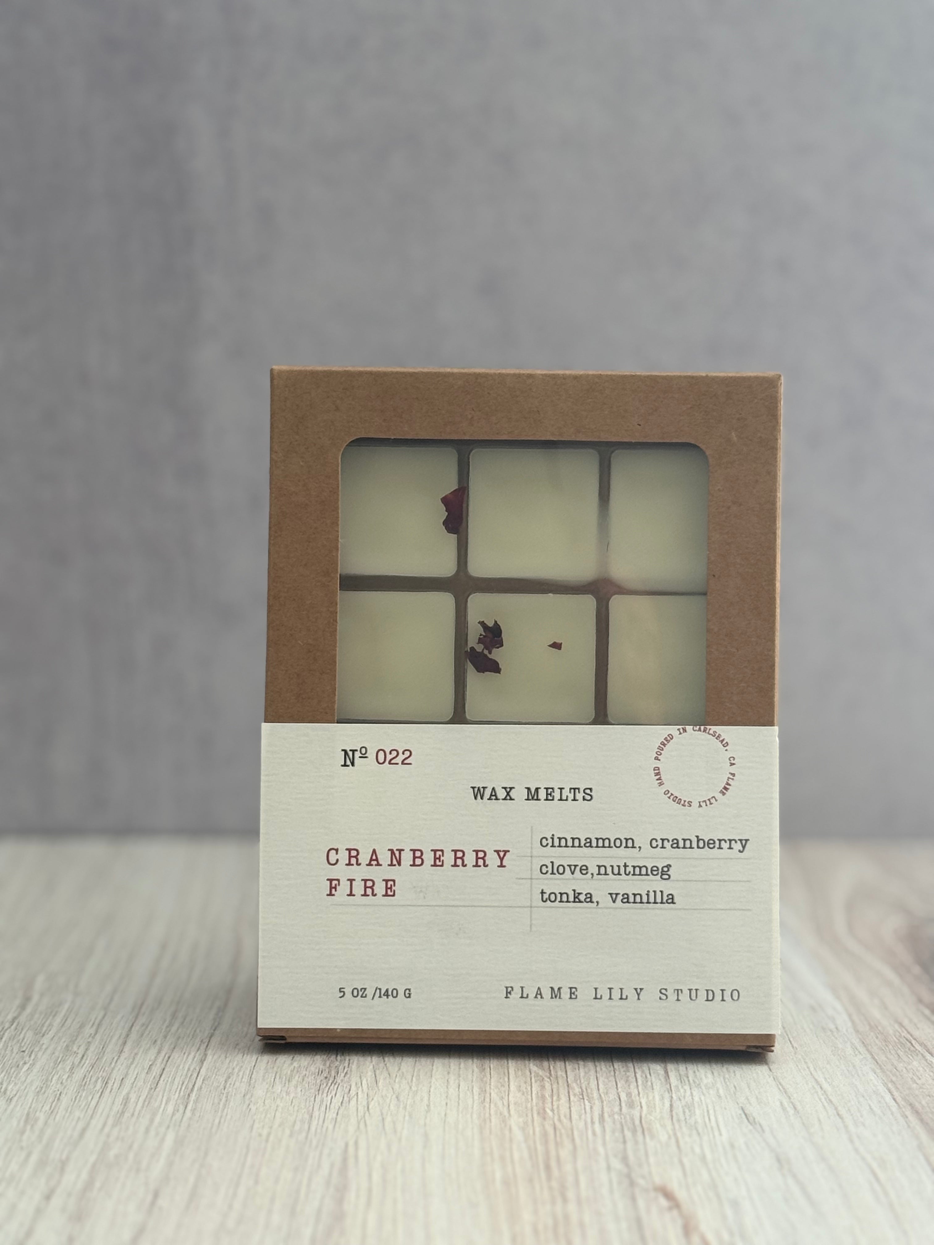 Wax melts packaging with 'Cranberry Fire' scent on a wooden surface.